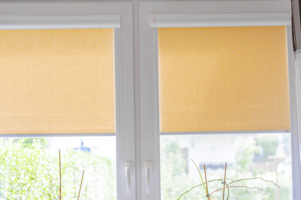 żółte rolety wewnętrzne zamontowane na białym oknie 